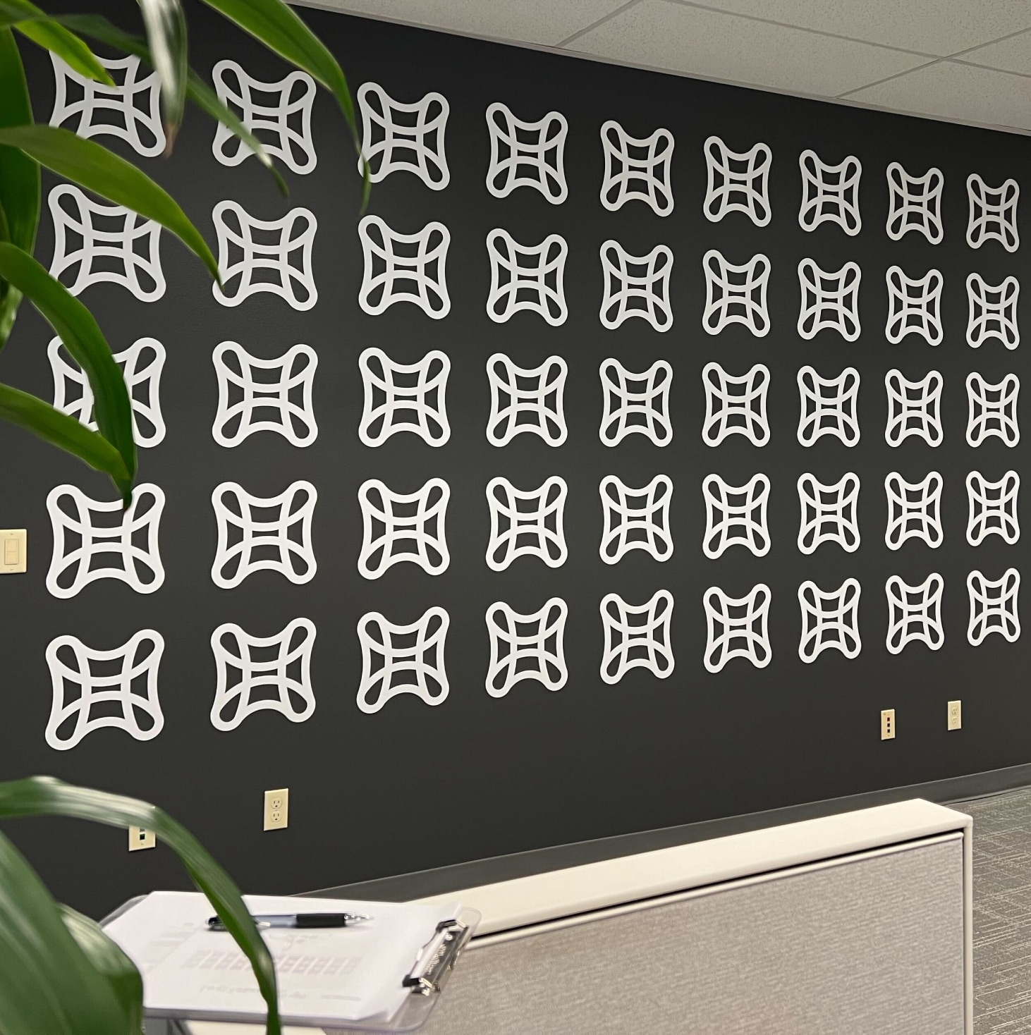 Black wall in Catalynt office with white logo mark