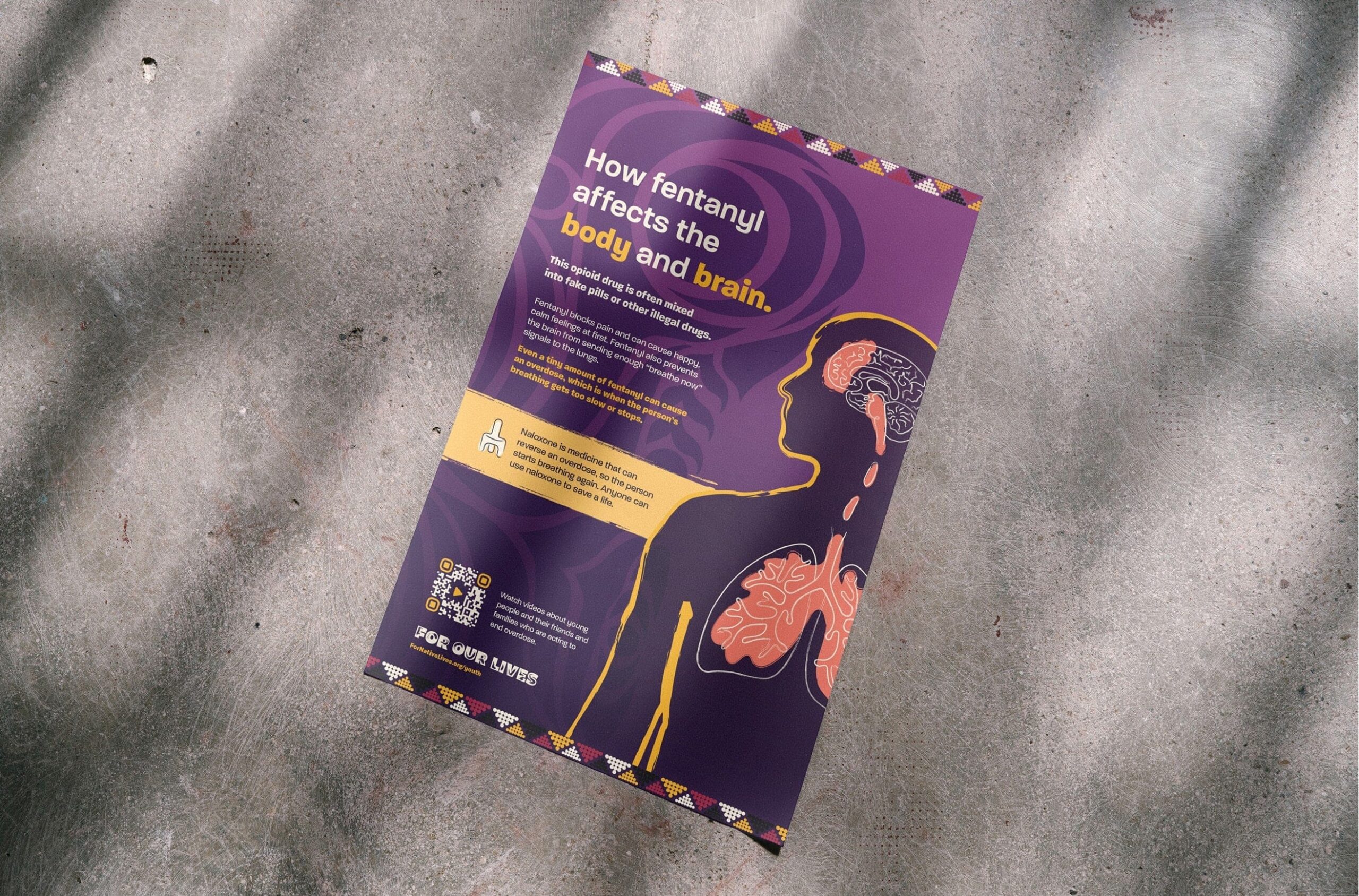 A picture of a poster lying on a concrete surface. The poster is designed for Native youth and explains how fentanyl affects the brain and lungs, why even a small amount can cause an overdose, and how naloxone can reverse one. 