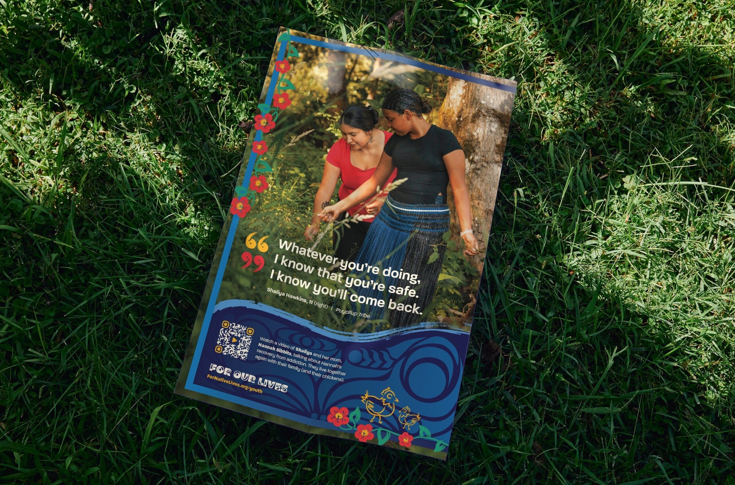 A photo of a poster lying on grass. The poster features a photo of Shaliya Hawkins and her mother, Hannah Sibbits, reaching toward the plants together in a leafy, wooded area. A quote from Shaliya reads: 'Whatever you're doing, I know that you're safe. I know you'll come back.' 